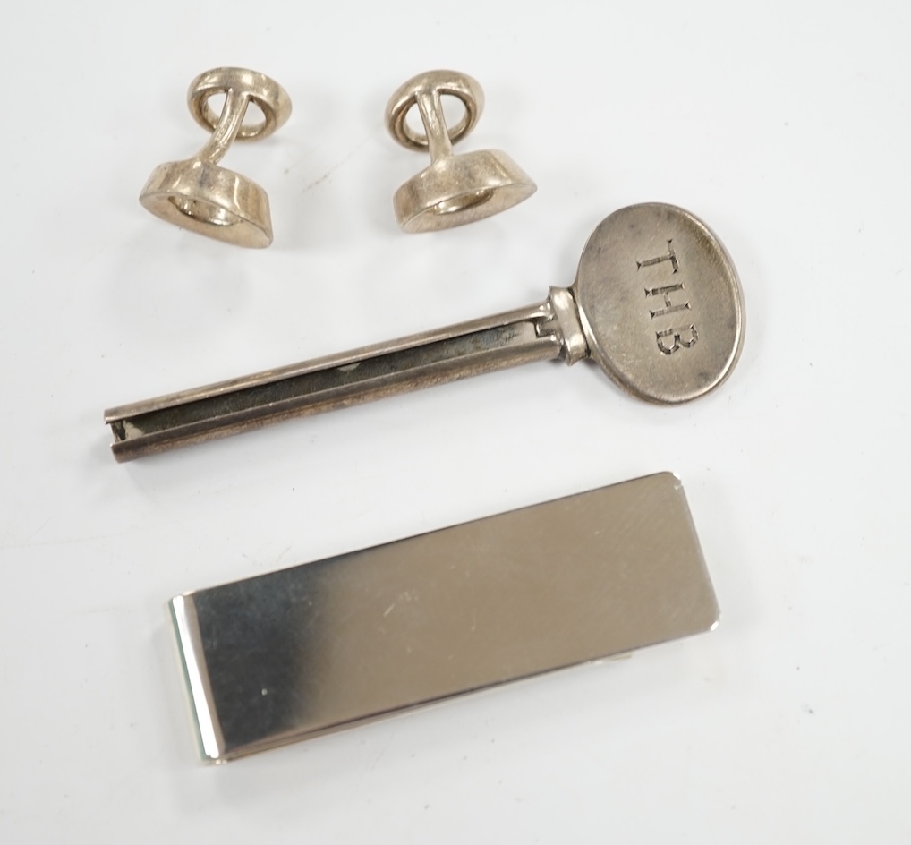 A group of Tiffany & Co sterling novelties; a pair of Frank Gehry Morph cufflinks, a toothpaste winder and a money clip, 57mm. Condition - fair to good